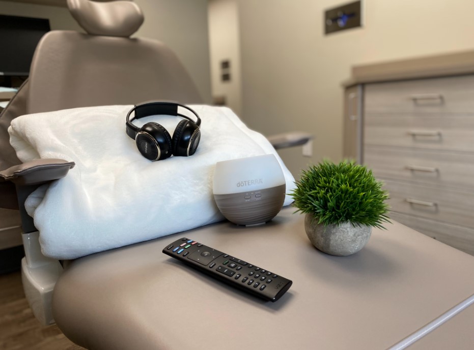 A dental chair at one of our Nebraska Family Dentistry locations with headphones, tv remote, and blanket. At NFD your comfort is always our priority.